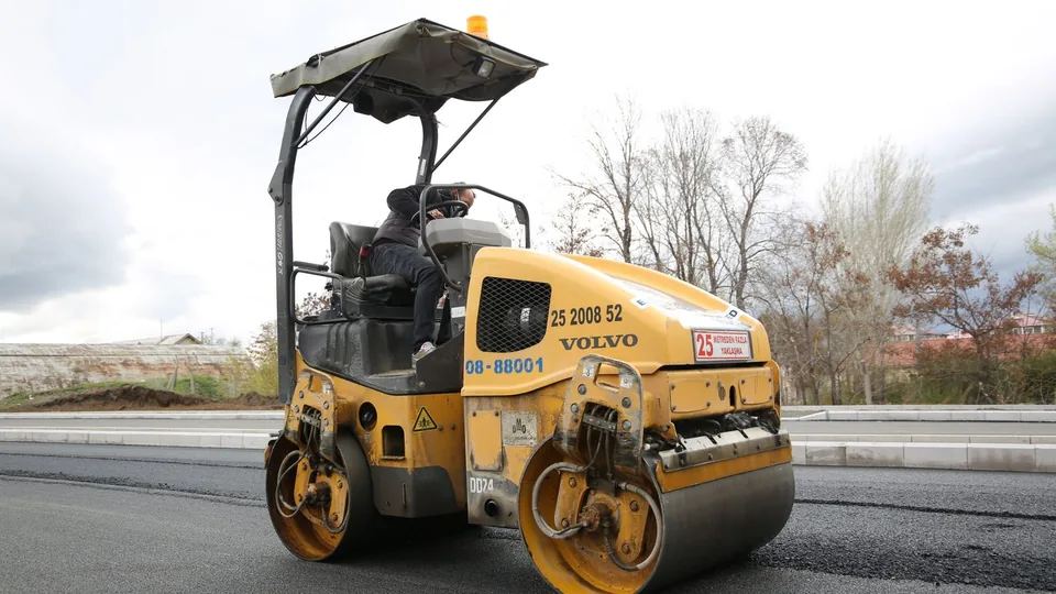 A steel-drum roller compacting a freshly laid layer of asphalt